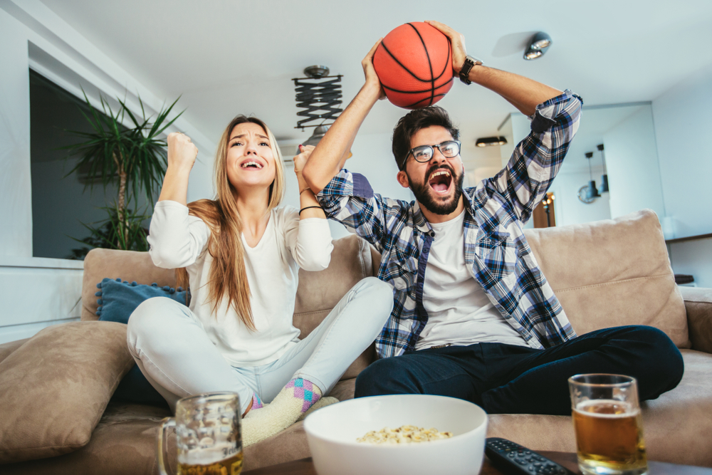 man and woman watching a basketball game