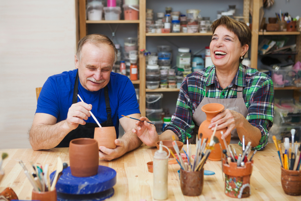 Older couple painting pots together