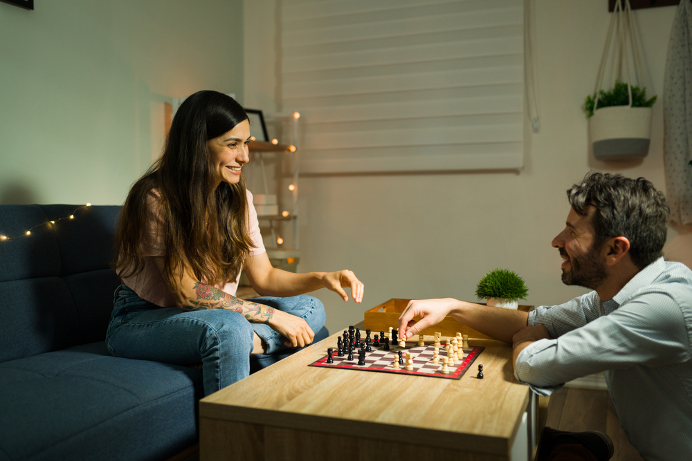 Couple smiling while playing chess