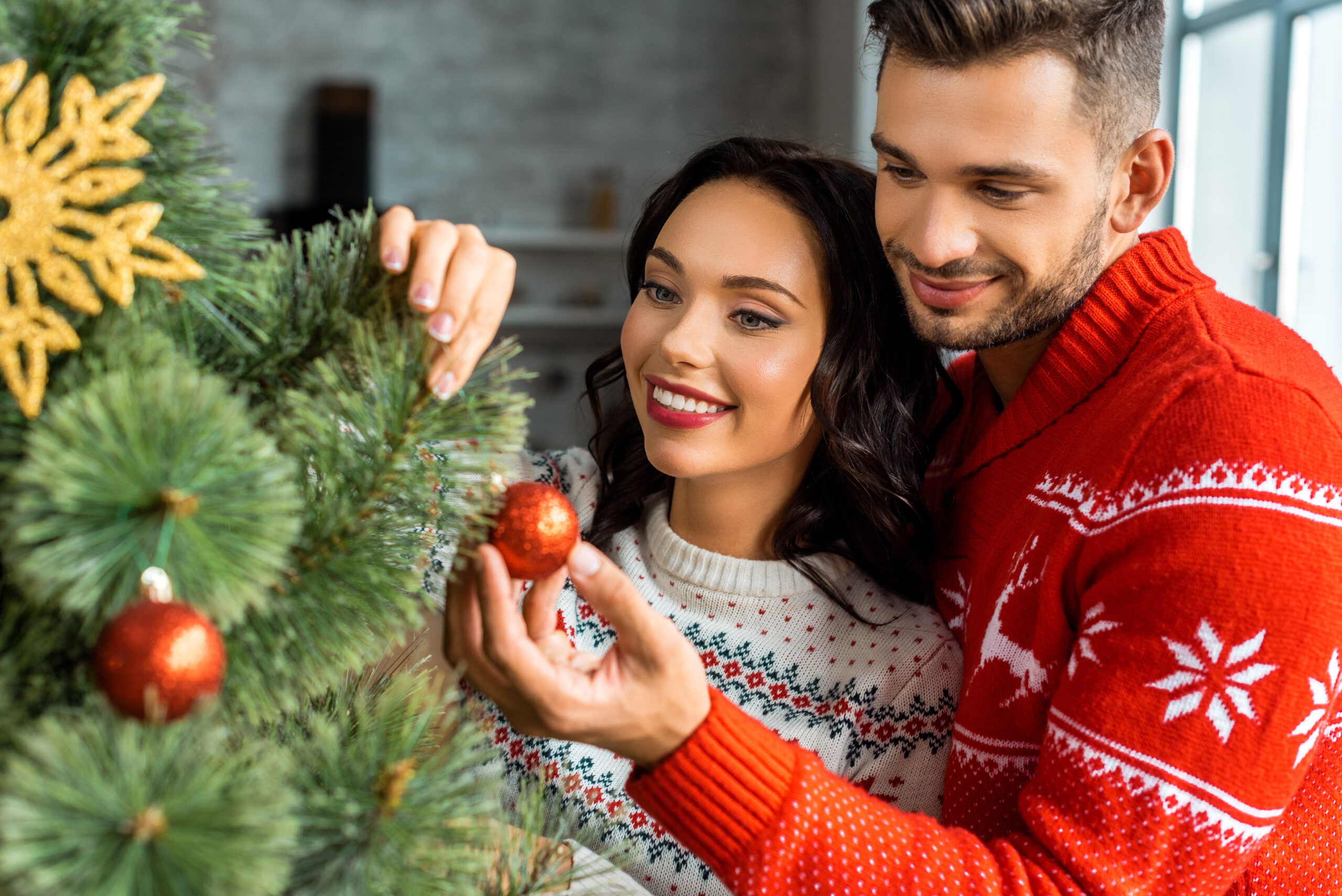 couple checking out decorations on their christmas tree