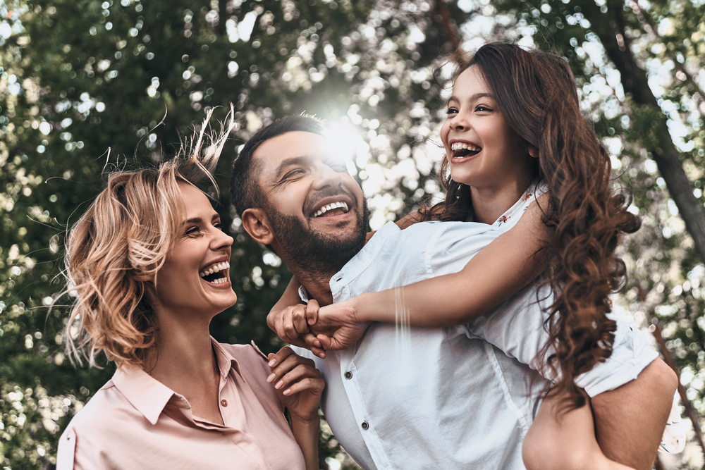 family of three smiling outside