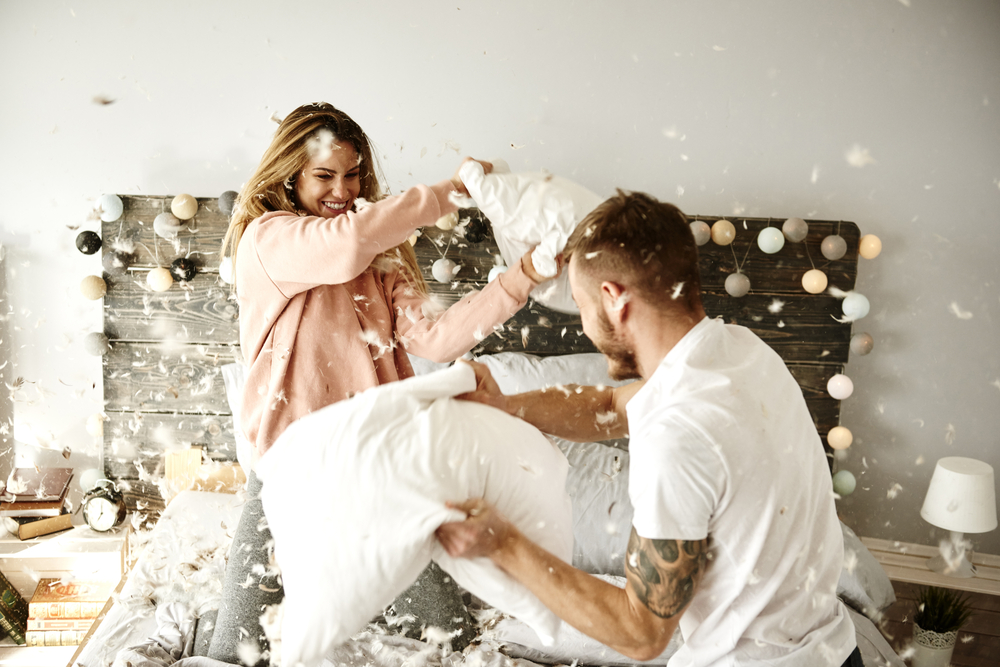 husband and wife having a pillow fight