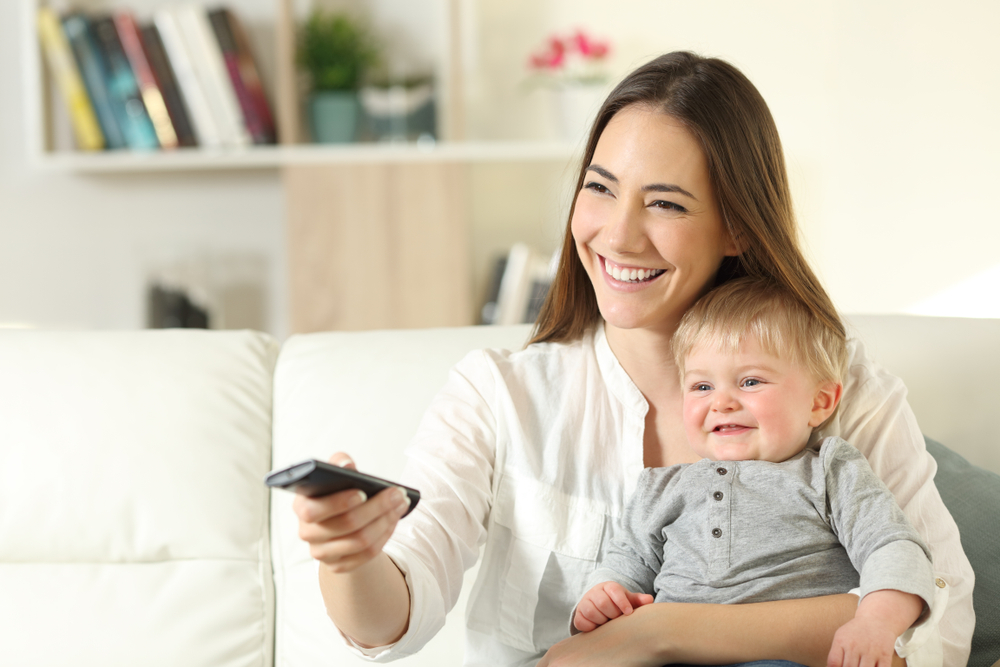 Child and mother watching television together