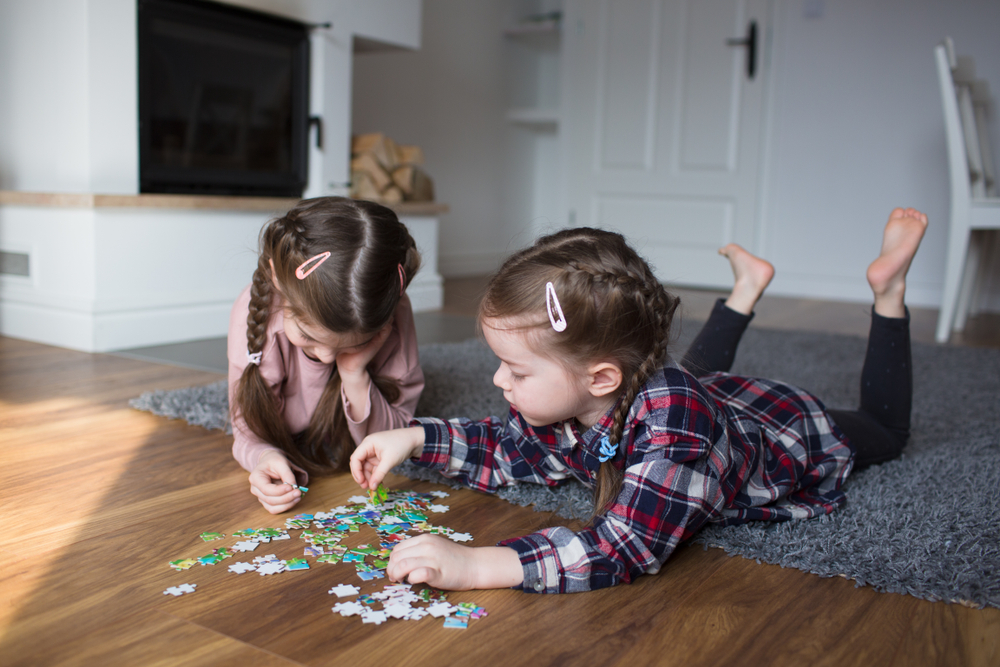 Children doing a puzzle on the floor, one of the best calming activities for kids
