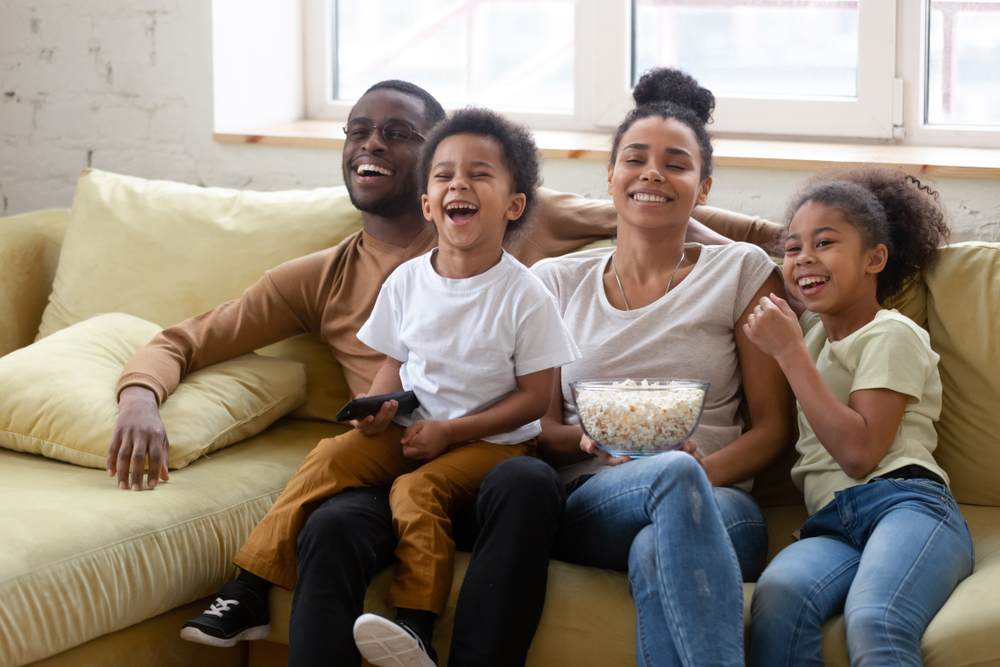Family of four watching a movie with popcorn