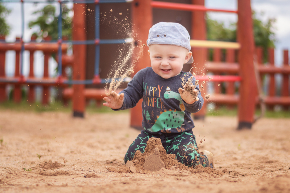 Little boy having fun playing in sand