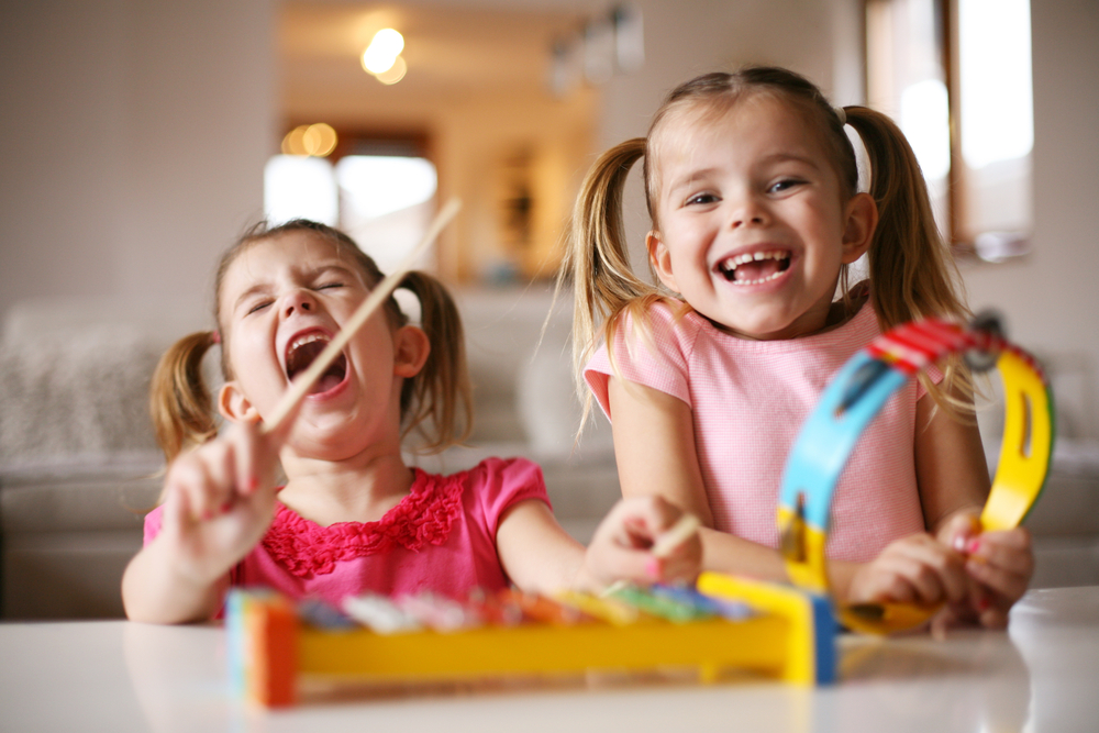 Little girls smiling playing instruments